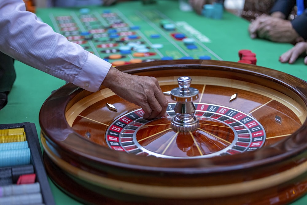 Pemain mengamati meja roulette dengan dealer di kasino
