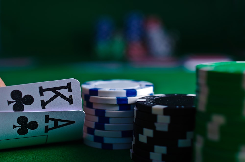 Keripik poker dan kartu terbentang di atas meja hijau
